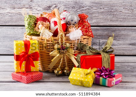 Many Christmas gifts near the basket with balls. Preparation for Christmas. Beautiful decorations for the home.