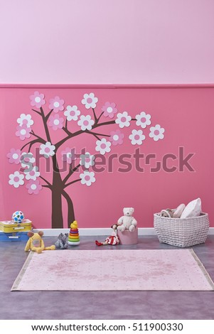 Empty children's room with basket, toys and wooden horse, pink wall and tree patterns
Decorative interior design with