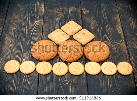 Pyramid of various types and forms of biscuit. Dark wooden vintage background.