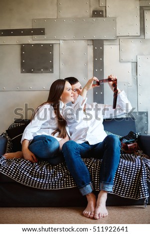 Pregnant couple looking photos on photographic film holding in hands