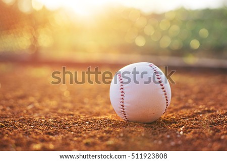 Baseball ball on pitchers mound. Baseball field at sunset
