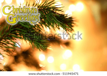 Green Coniferous tree pine blurred branch on yellow gold bokeh lights background. Decorated text Christmas Greetings design hand writing font. Concept corner for New Year congratulations blank card. 