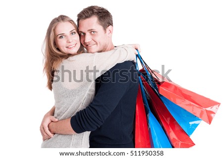 Attractive couple embracing and holding bunch of shopping bags and smiling isolated on white background with copy text space