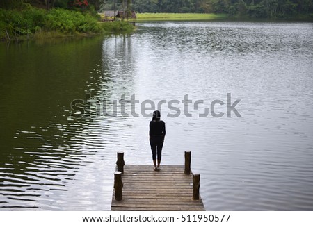 Woman feeling victorious facing on the bridge in the lake, Thailand