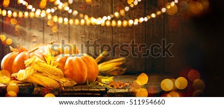 Happy Thanksgiving Day background, wooden table decorated with Pumpkins, Corncob, Candles and autumn leaves garland. Beautiful Holiday Autumn festival concept scene Fall, Harvest.