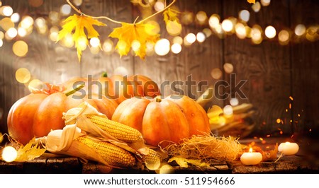 Happy Thanksgiving Day background, wooden table decorated with Pumpkins, Corncob, Candles and autumn leaves garland. Beautiful Holiday Autumn festival concept scene Fall, Harvest.