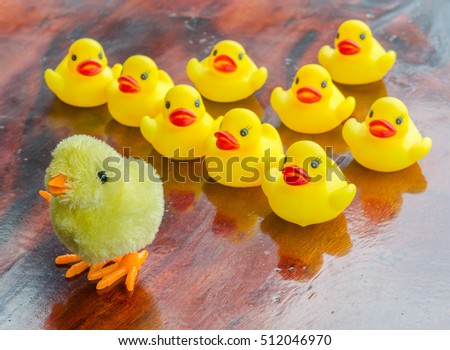 Duck and chick dolls, toys for children, on a table made of wood and background bokeh tree. (Select focus)