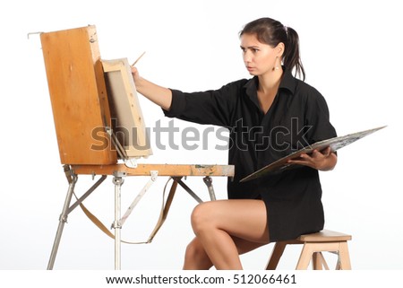 A young woman in a black shirt draws a picture.
