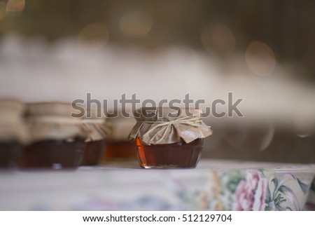 Jars of honey on a table covered with a film.
