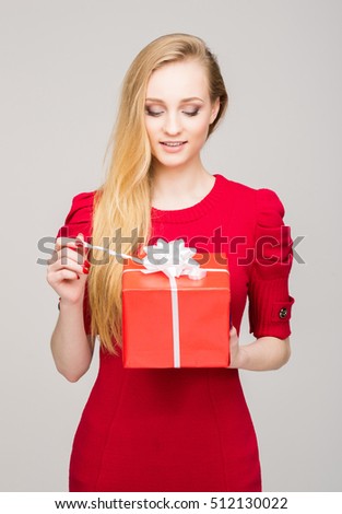 Portrait of young, pretty and happy teenage girl with a Christmas gift box. New year concept.