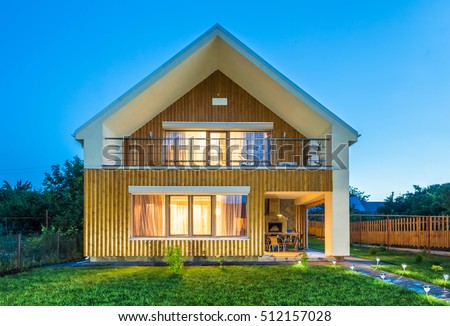 Beautiful wooden house with a lawn. Royalty-Free Stock Photo #512157028