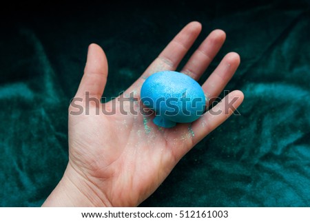 fantastic blue mushroom in the hand on green velvet background
