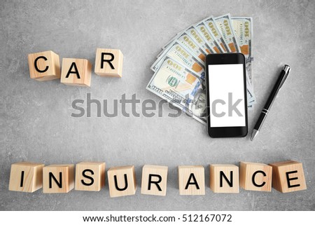 Cubes with words CAR INSURANCE, dollar banknotes and smart phone on grey background, top view