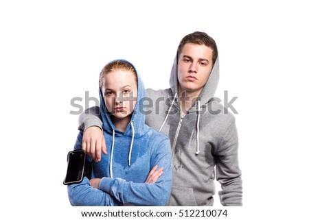 Teenage boy and girl in sweatshirts. Studio shot, isolated.