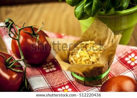 cheese muffin, tomato and basil on checkered napkin on wooden background