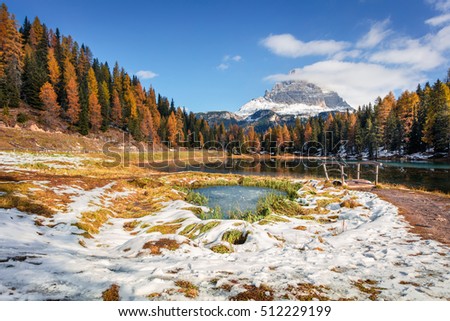 Splendid sunny scene on Antorno lake with Tre Cime di Lavaredo (Drei Zinnen) mount. Colorful autumn landscape in Dolomite Alps, Province of Belluno, Italy, Europe. Artistic style post processed photo.
