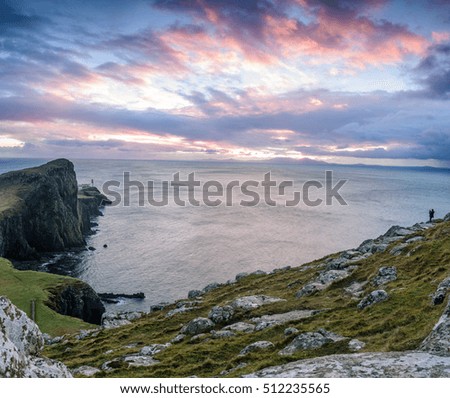 Neist point lighthouse, Isle of Skye, Scotland - beautiful landscape image of this iconic location at sunset - panorama with a man trying to take a photograph