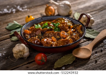 Meat stew with vegetable on rustic wooden background Royalty-Free Stock Photo #512243932
