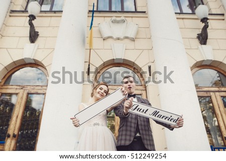bride and groom with handmade just a married signs. wedding day.