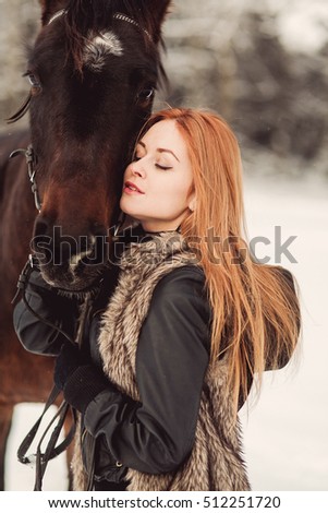pretty woman posing on horse in winter park