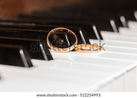 gold wedding rings on a piano key