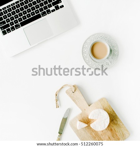 Flat lay modern feminine home office workspace. Laptop, coffee cup, cheese and knife on white background. Top view