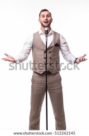 Young man in suit singing over the microphone with energy. Isolated on white background. Singer concept.