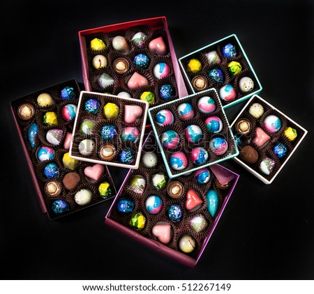 Chocolate handmade candy sweets in a gift boxes. Black background.
