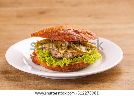 Delicious original american hamburger with grilled beef, bacon and vegetables on white plate, snack or lunch, product photography for restaurant or bistro
