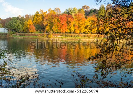 Colorful italian park with trees and autumn colors and water