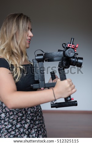 Professional  woman videographer with gimball video slr