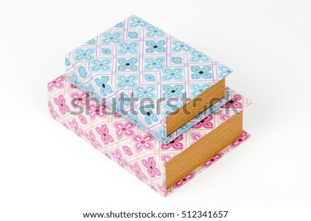 Decorative book - storage box, gift box. Old vintage boxes for storage on the bookshelf. Vintage ornaments. Shabby chic style. Retro. Isolated on white background. Pink and blue boxes. Closeup. 