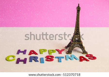 Christmas ornament with Eiffel tower on wooden background with Happy christmas text and snow