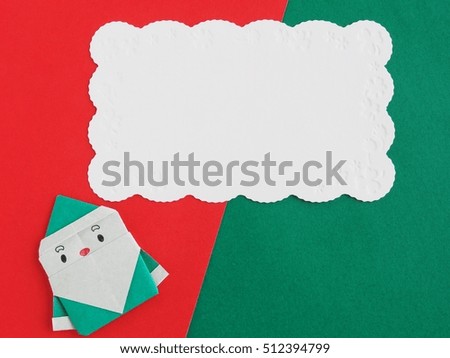 Santa Claus of paper craft and blank christmas message card on red and green background