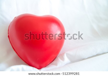 red heart shape on white bed 