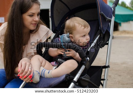 Young mother is walking with her small child in the park