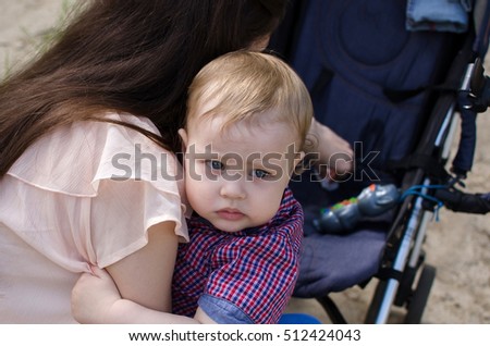 Young mother is walking with her small child in the park