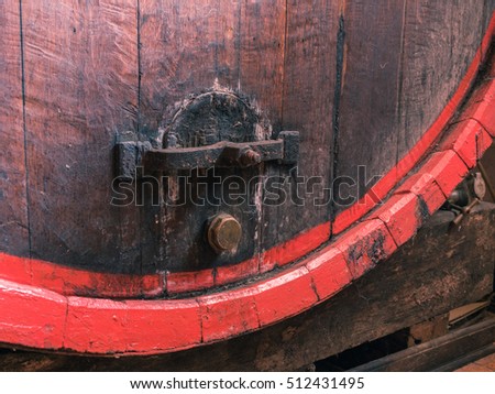 Picture of a brown wine barrel stacked in the old cellar of the winery. Background of the wooden barrel made of brown planking close up.