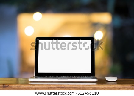 Blank screen of Laptop and office supplies in night room working place at night.