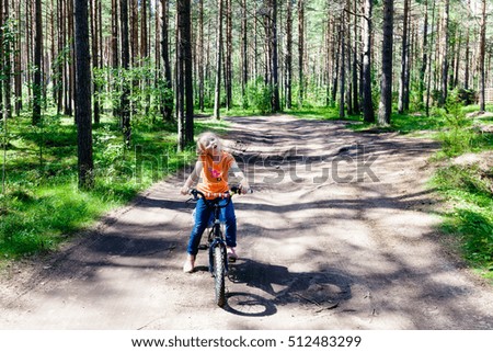 Girl riding her bike in the woods