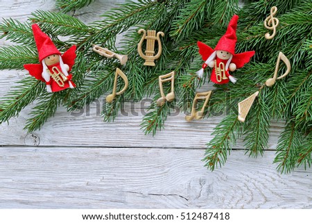 Angels with instruments, music notes , christmas tree on wooden background 