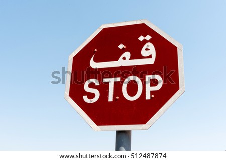 Red stop sign in English and Arabic