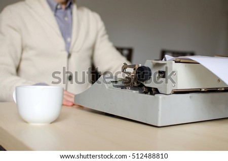 Close-up photo of the back side of the typewriter and cup of coffee