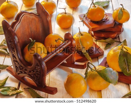 Wooden armchair with tangerines with leaves on the wooden background