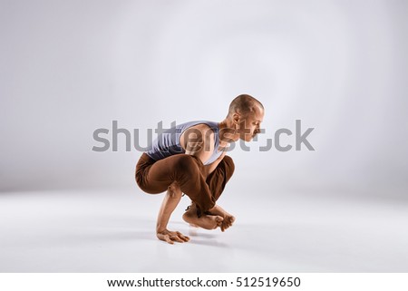 Sporty middle age man doing yoga practice isolated on white background - concept of healthy life and natural balance between physical and mental evolution