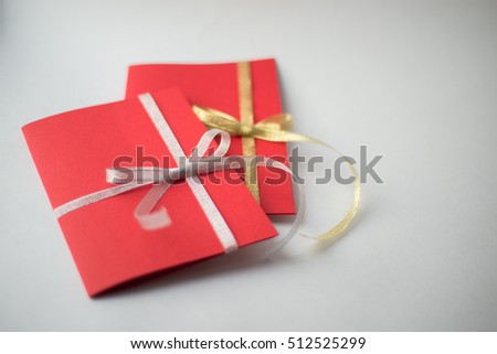 close up of two red greeting cards with ribbon bows on white background with copy space