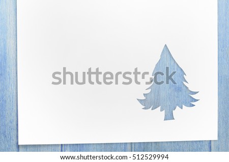 Cut paper in christmas tree shape for christmas card or new year background on wooden table