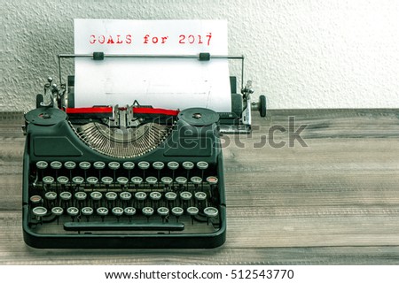 Typewriter with white paper page on wooden table. Goals for 2017. Vintage style toned picture