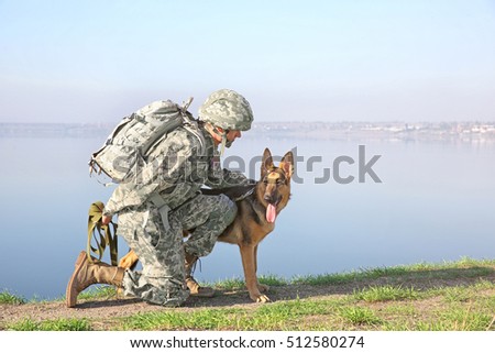 Soldier with german shepherd dog near river Royalty-Free Stock Photo #512580274