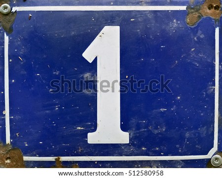 Closeup of street number one on a blue metal board